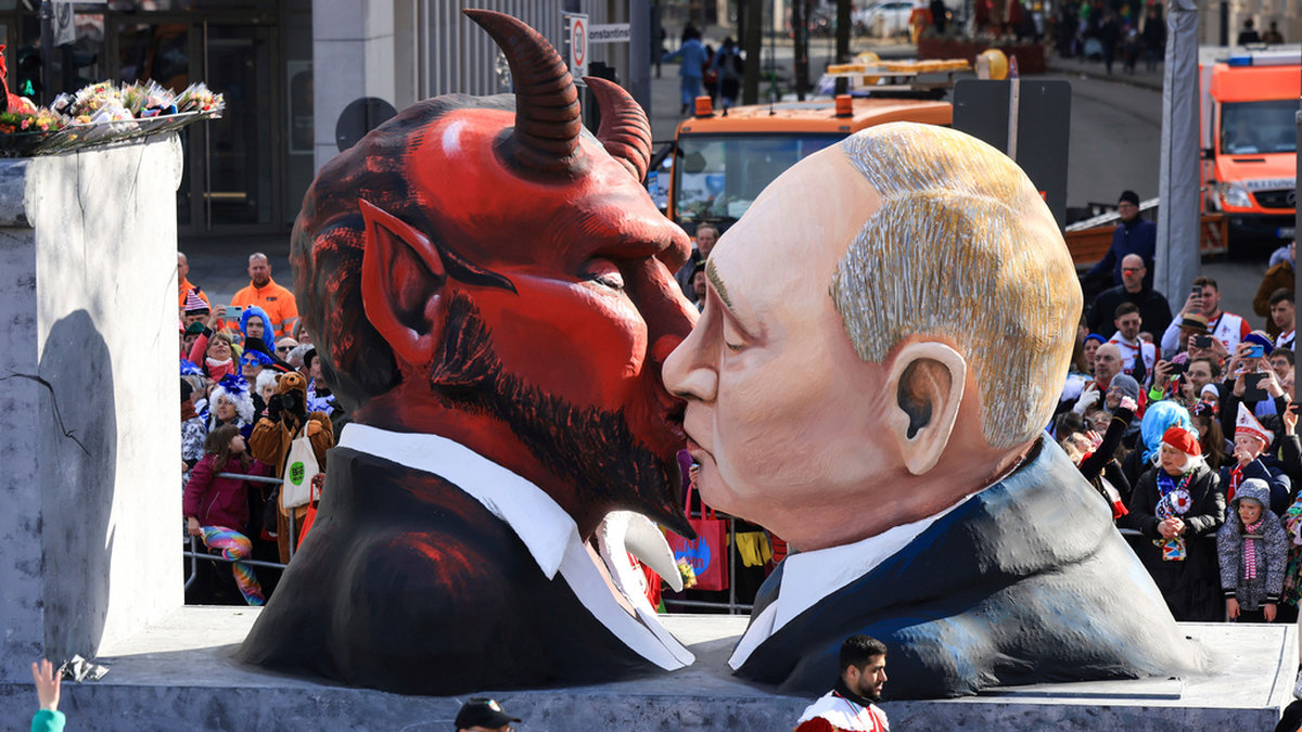 Rysslands president Vladimir Putin kysser djävulen, ett inslag i karnevalståget i Köln i Tyskland. Samma dag började en symbolisk rättegång mot Putin i Haag i Nederländerna.