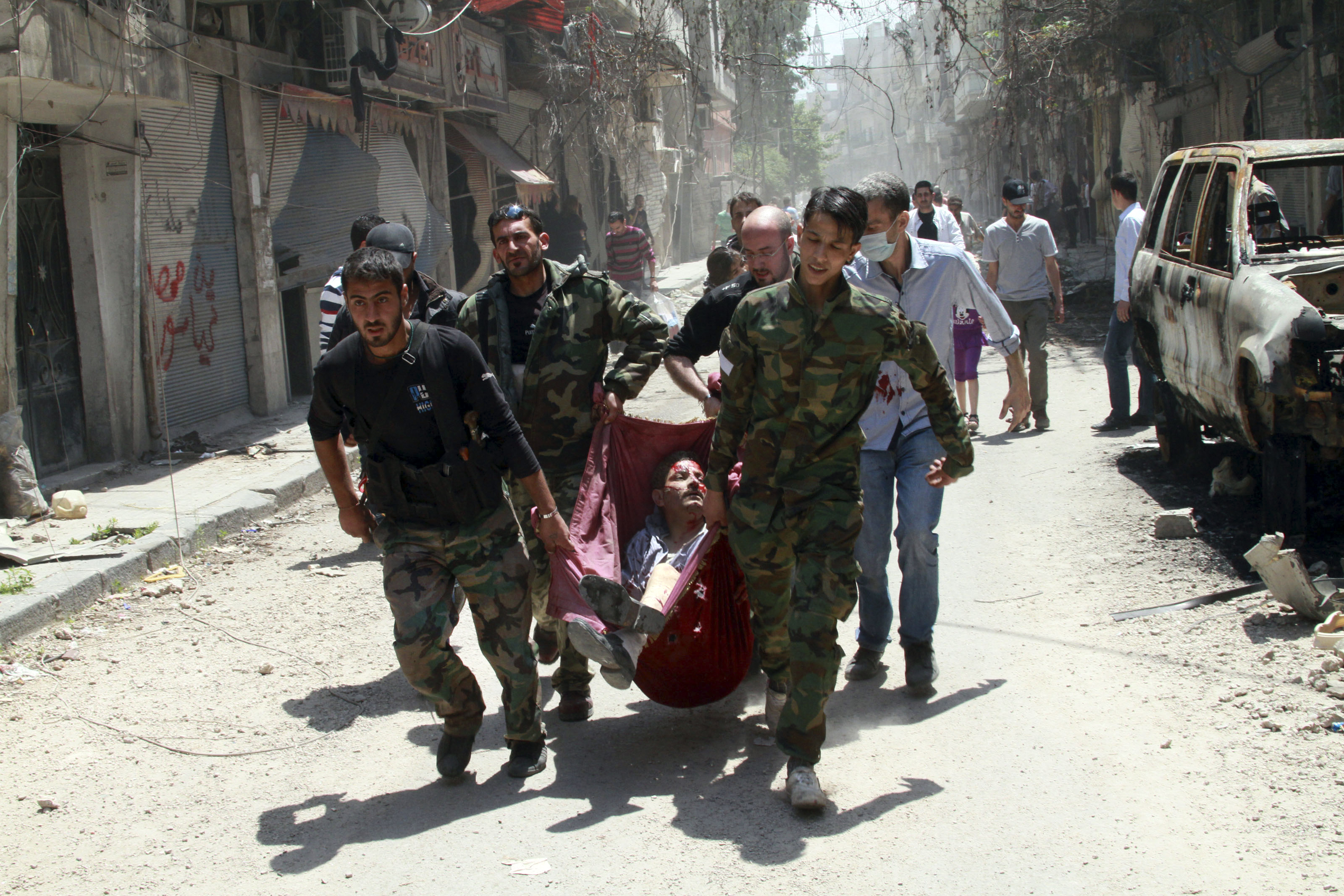 En man som skadats av en landmina bärs bort. Homs, Syria. 