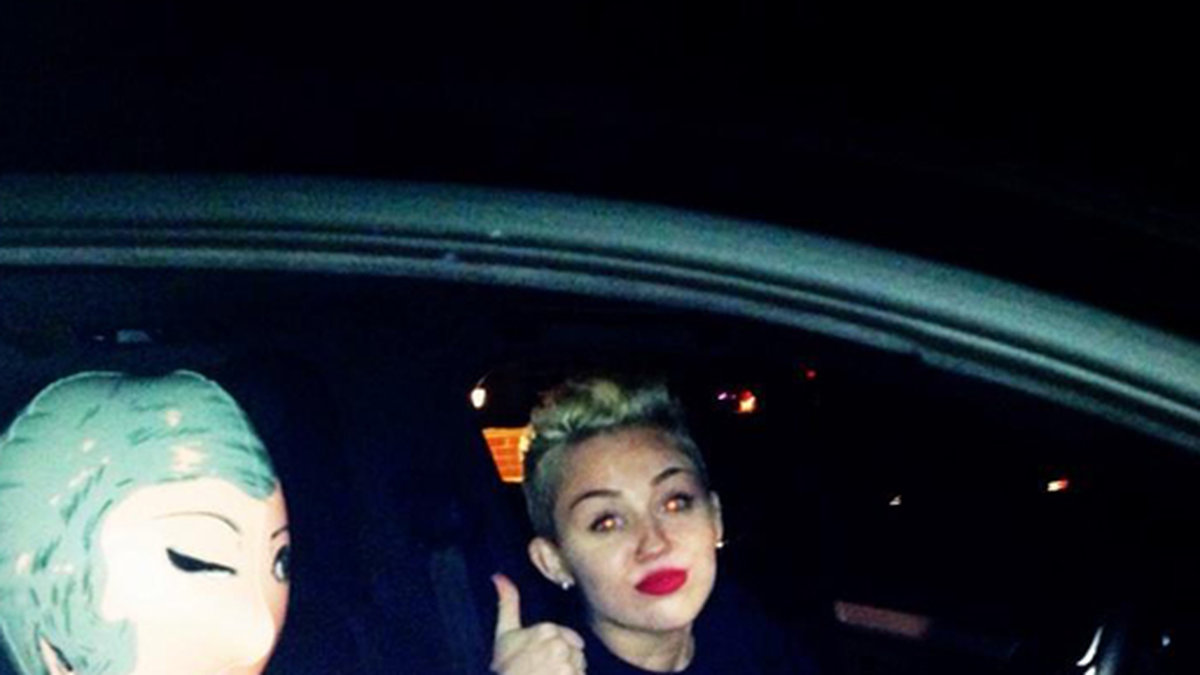 Miley Cyrus poserar med en uppblåsbar sexdocka i sin bil.
