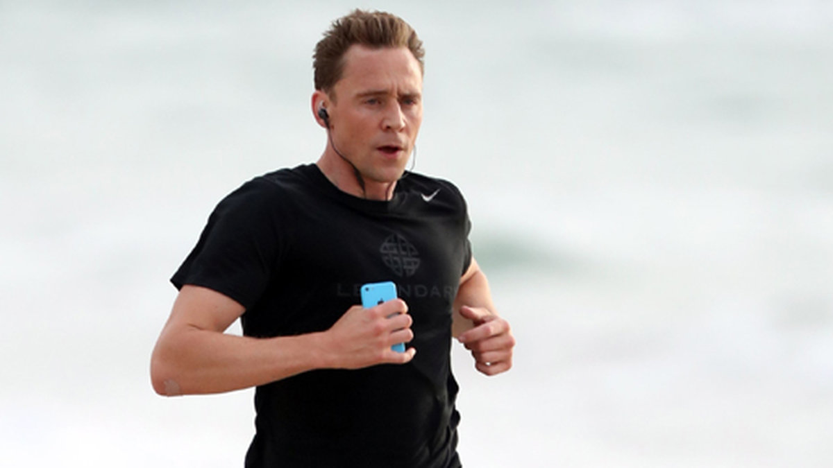 Tom Hiddleston ligger inte och latar sig – här tar har en joggingtur på stranden. 
