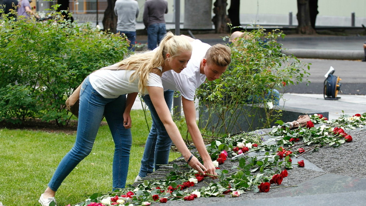 Många lade rosor på minnesplatsen i regeringskvarteren.