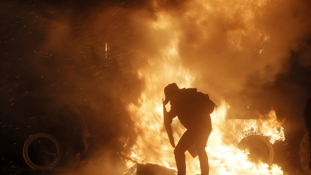 En demonstrant försöker skydda sig mot elden.