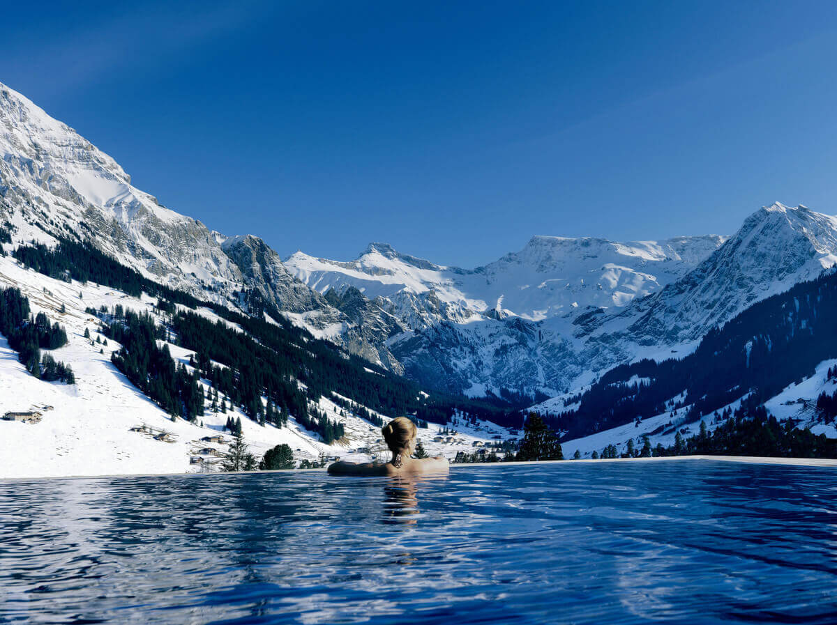 The Cambrian Adelboden, Adelboden, Schweiz. Infinity-poolen har en utsikt över de snötäckta alperna. Den är öppen året runt. The Cambrian Adelboden, Adelboden, Schweiz. Infinity-poolen har en utsikt över de snötäckta alperna. Den är öppen året runt.