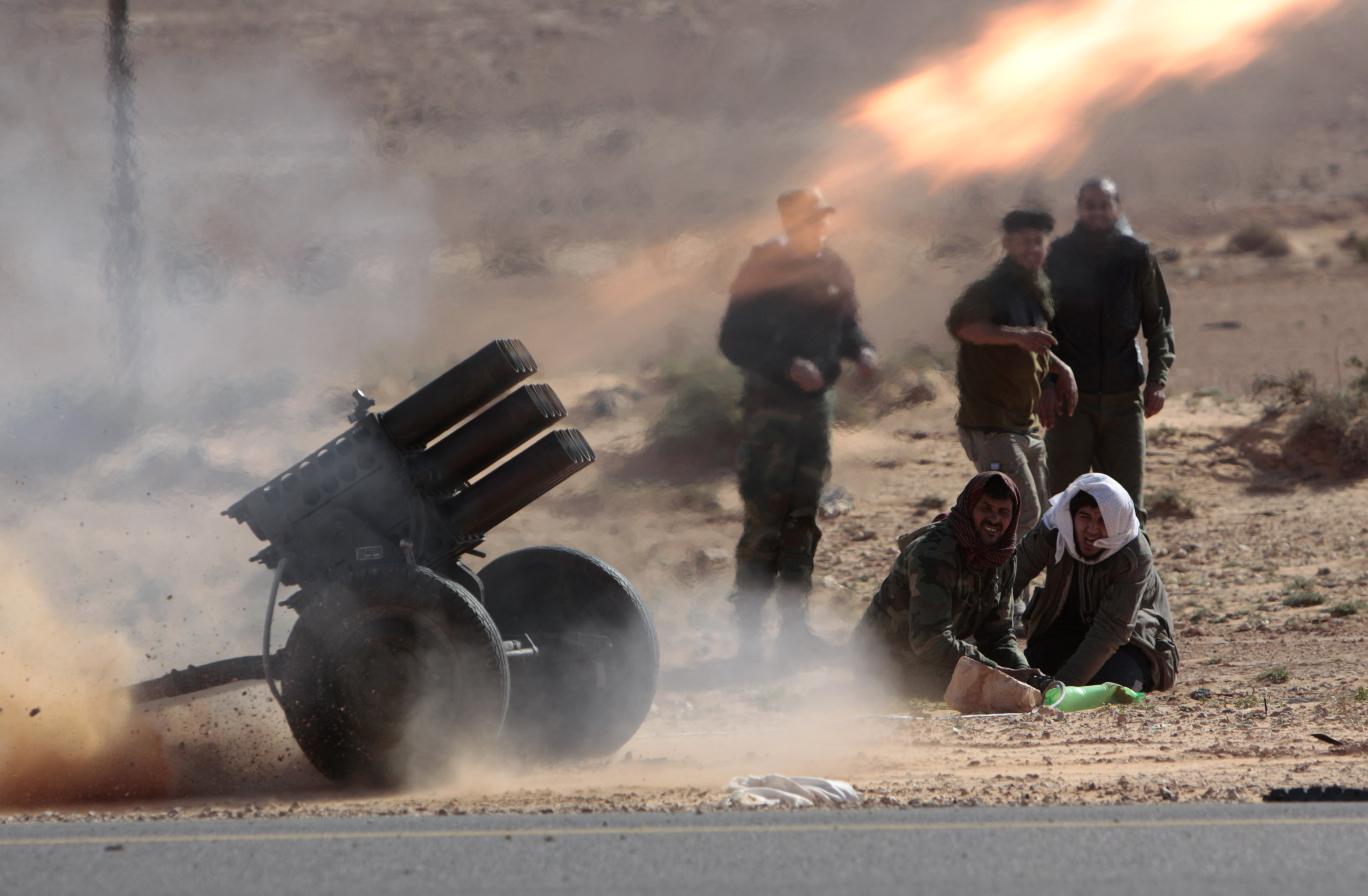 Rebeller avfyrar artillerield mot Khaddafis styrkor.