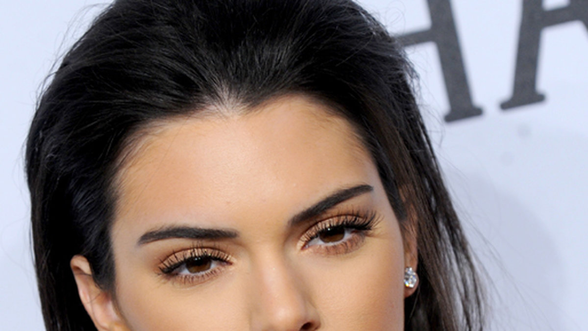 Kendall Jenner, som även är Estee Lauders ansikte utåt, med röda läppar och guldiga ögon på en gala i New York. 