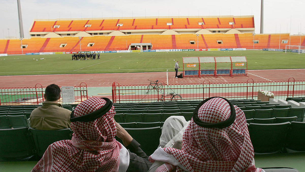Fotbollsarena i Riyadh med två saudiska män i förgrunden.