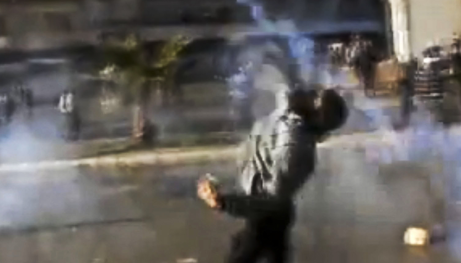En bild tagen från en statlig nyhetssändning. Enligt TV-kanalen kastar demonstranter tårgas mot militären. 