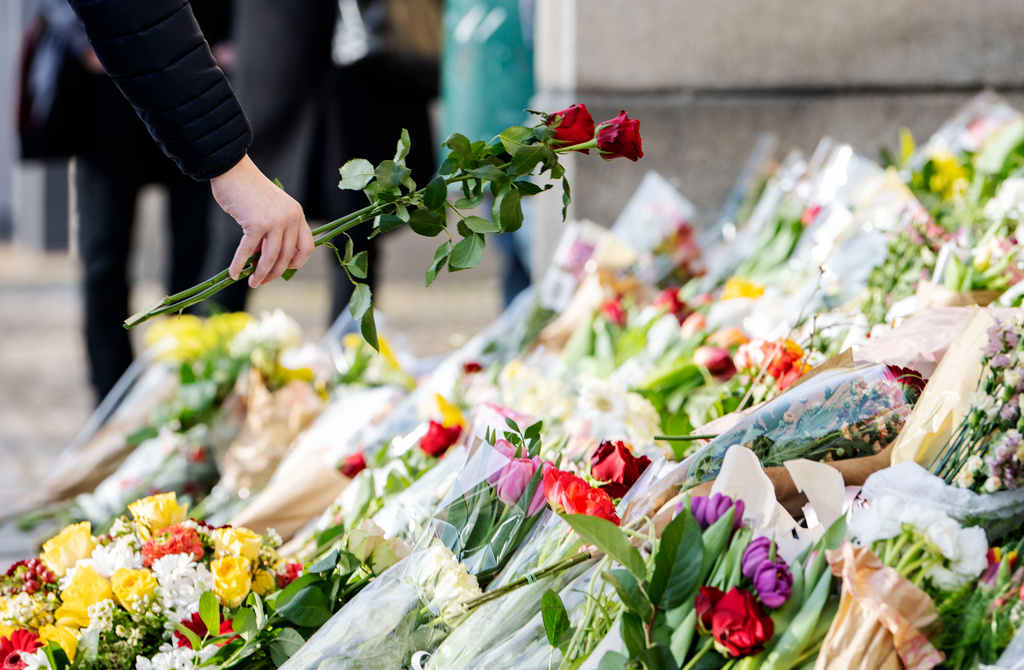 Rosor placeras i havet av blommor och ljus på trappan vid huvudentrén på Malmö Latinskola den 22 mars, dagen efter att två av skolans lärare dödats av en elev. Arkivbild.