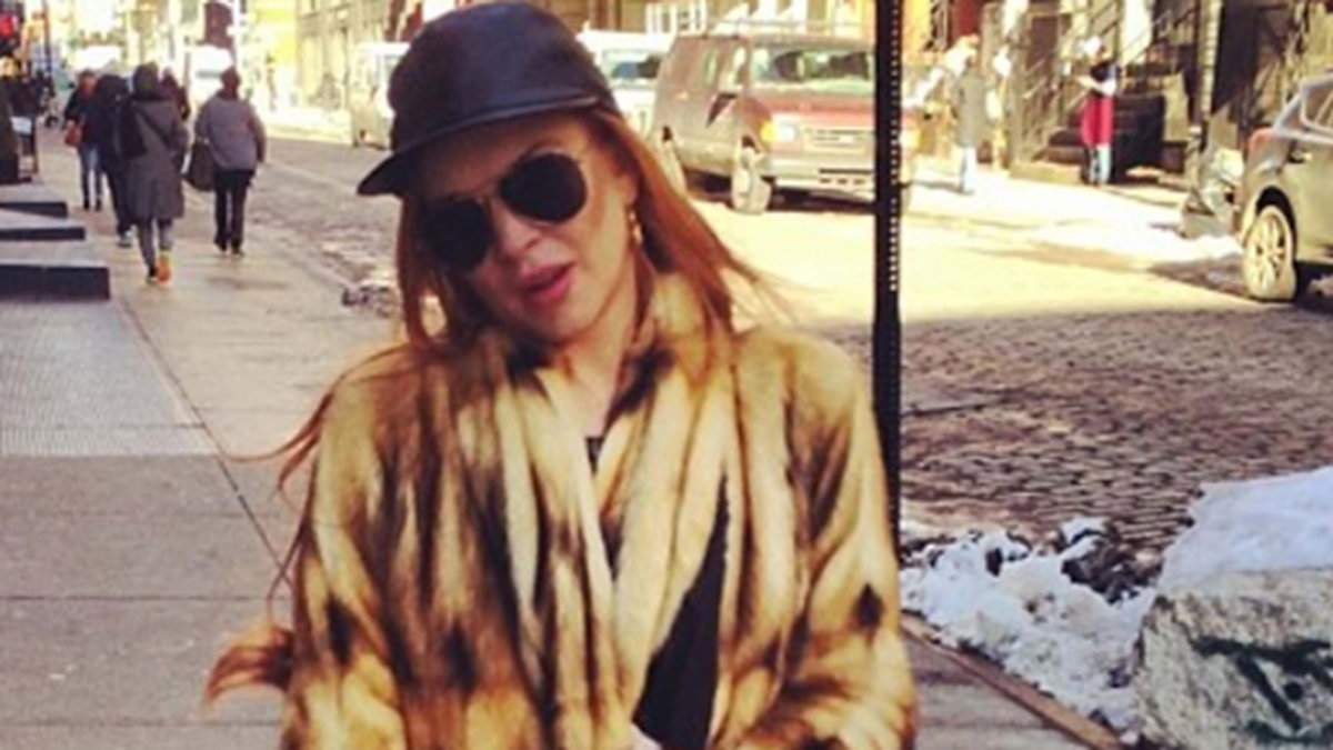 Lindsay Lohan värmer sig med en päls i New York.