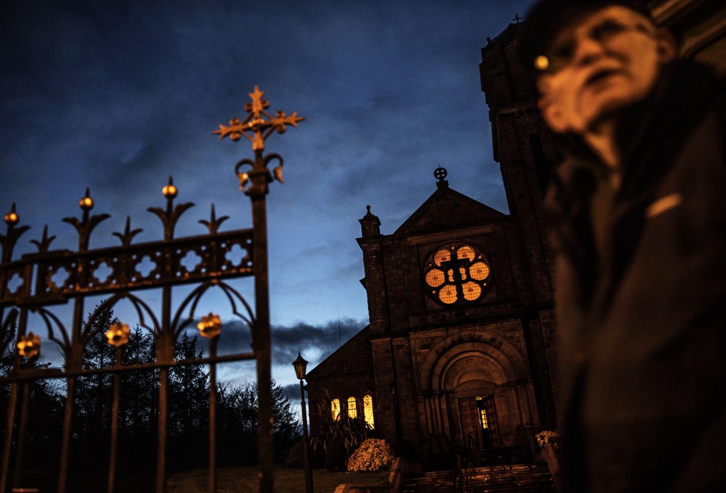 En fotgängare passerar en katolsk kyrka i nordirländska Aughnacloy. Arkivbild.