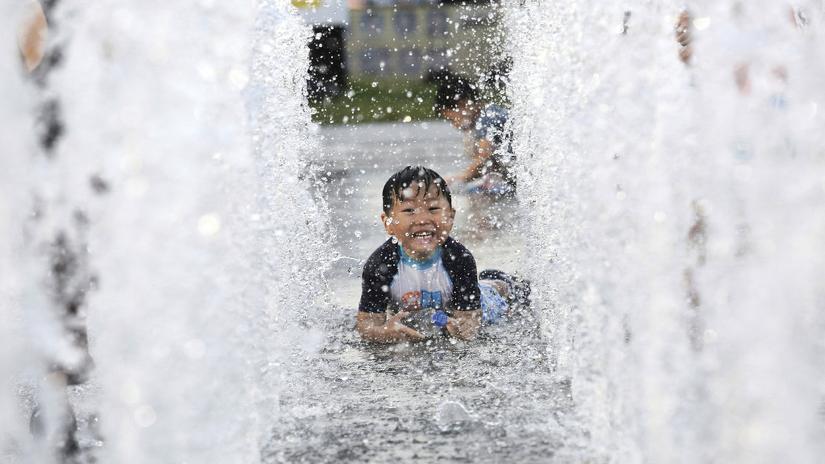 En pojke svalkar sig vid en fontän i Sydkoreas huvudstad Seoul. Arkivbild.