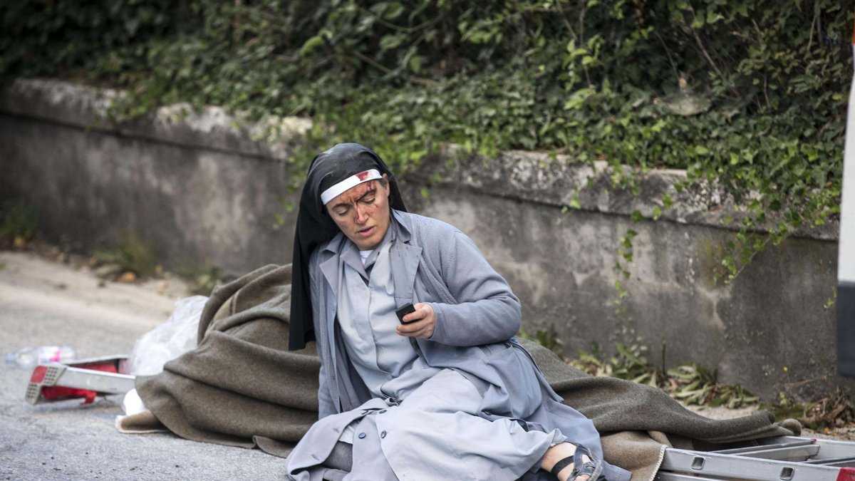 En nunna kollar sin telefon i Amatrice.