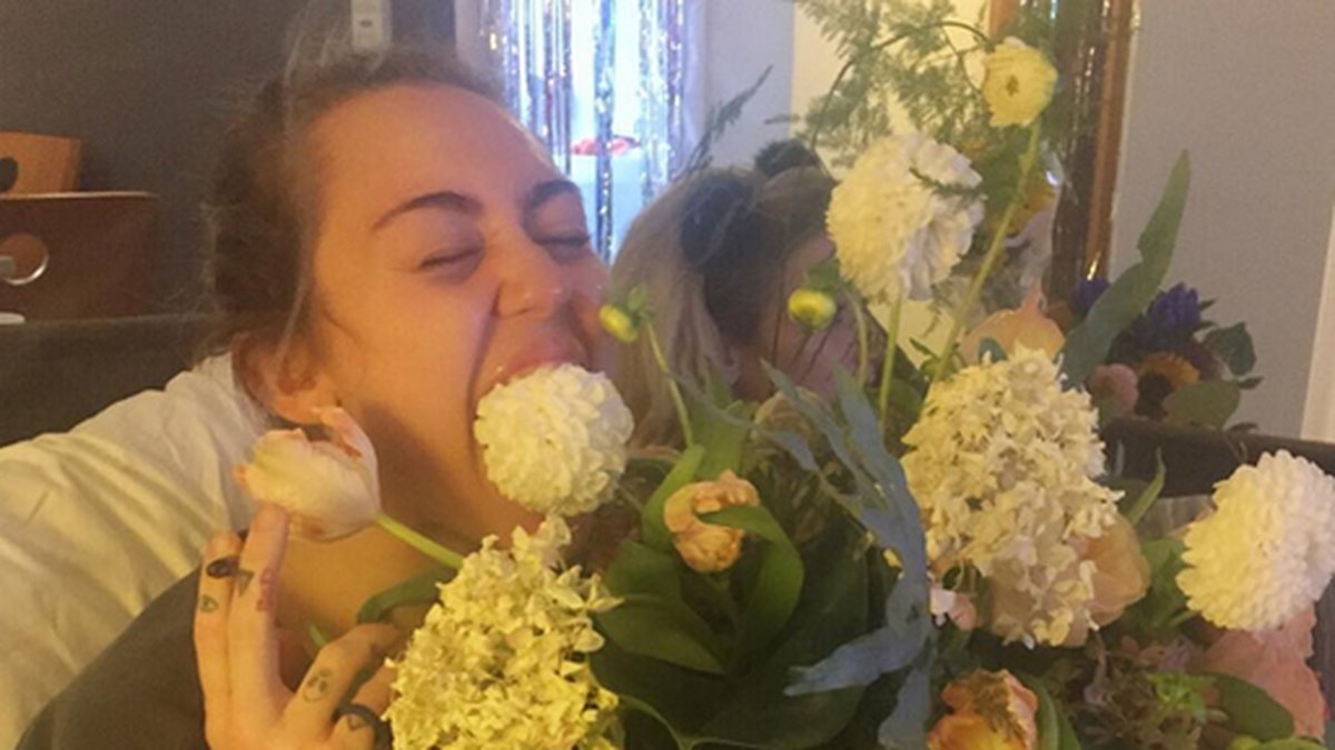 Miley Cyrus äter en blomma. 