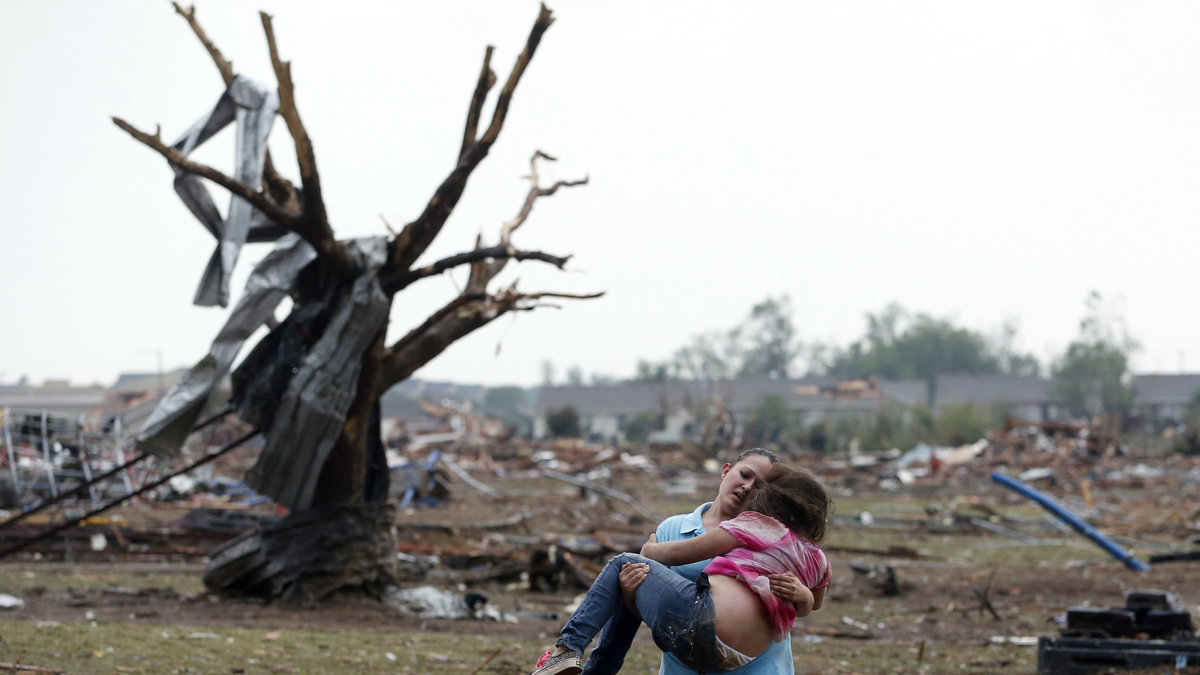 En kvinna med sitt barn i stormens förödelse.