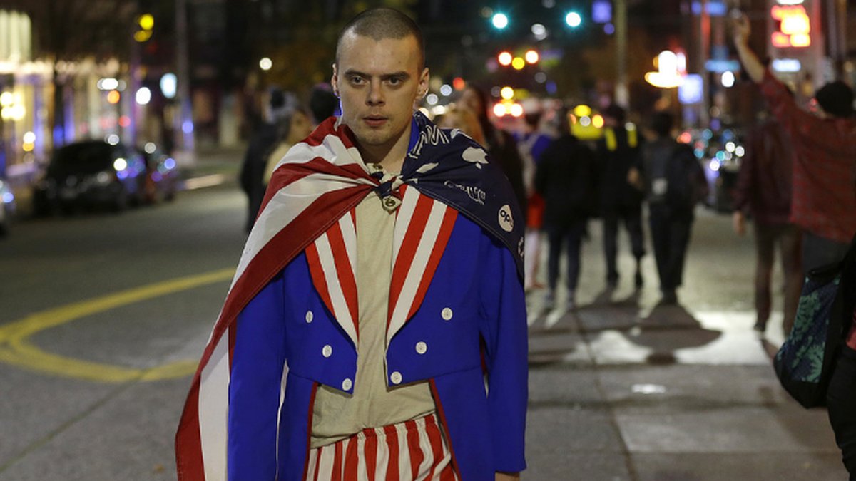 En arg demonstrant iförd den amerikanska flaggan, på Seattles gator.
