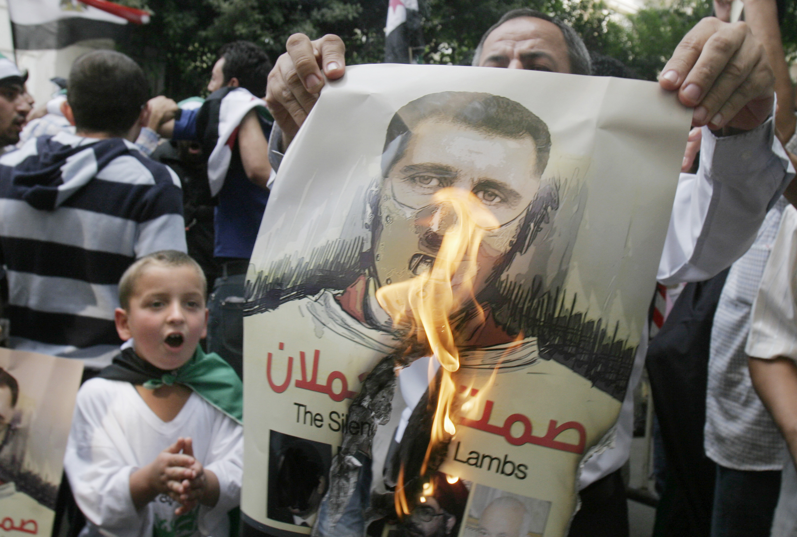 Folket kämpar för frihet och sina mänskliga rättigheter. Här eldar en rebell upp en bild som föreställer president Bashar al-Assad.  