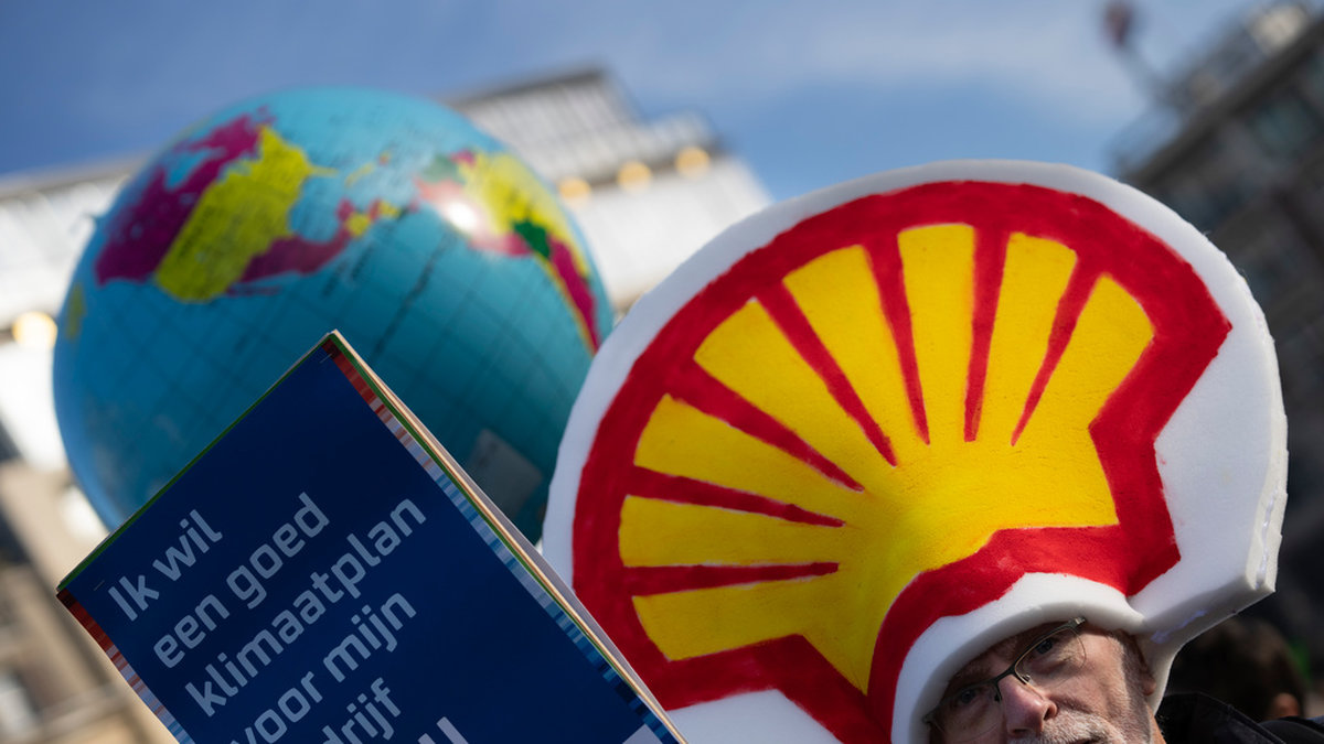 En man deltar i en klimatmarsch i Amsterdam i november 2023. I handen håller han en skylt med texten 'Jag vill ha en bra klimatplan för mitt företag Shell'. Arkivbild.