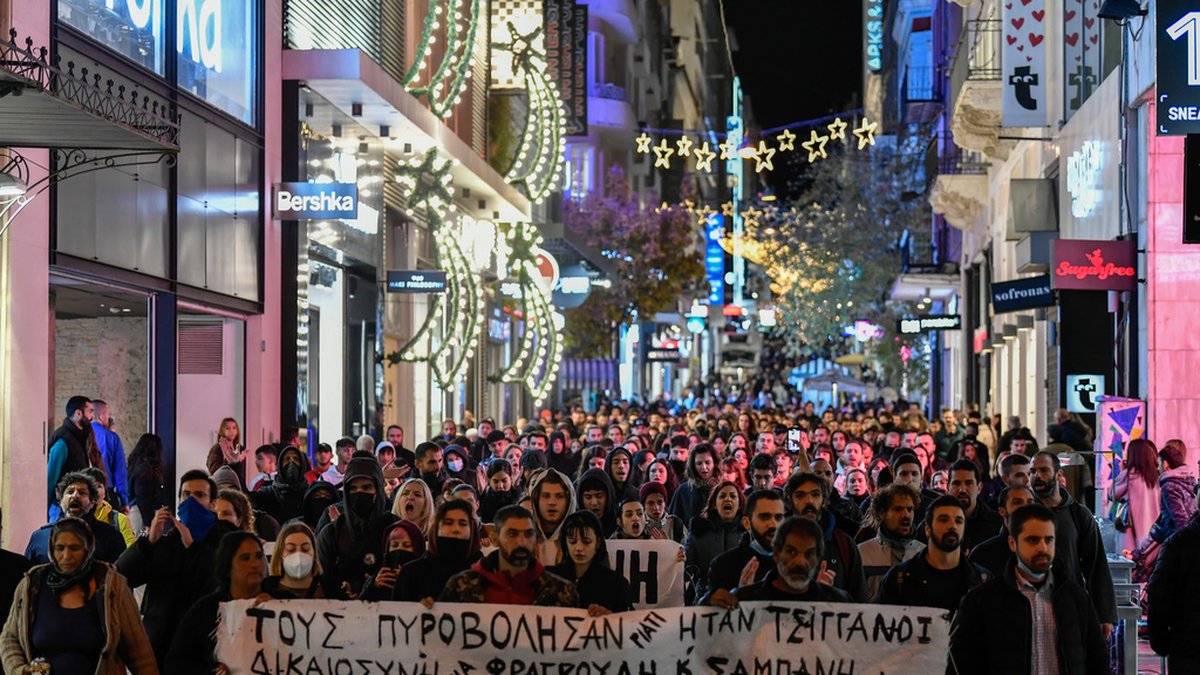 Demonstranter i Greklands huvudstad Aten med texten 'De sköt dem eftersom de är romer'.