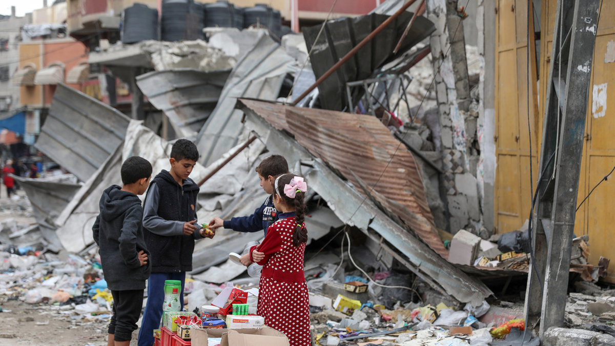 Palestinska barn framför en förstörd byggnad i Gaza. Arkivbild från i november.