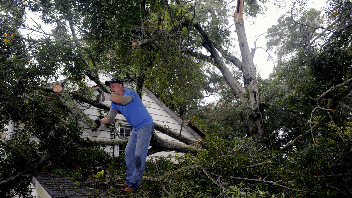 Här rensar en New Jersey-invånare sitt hustak från nedfallna träd.