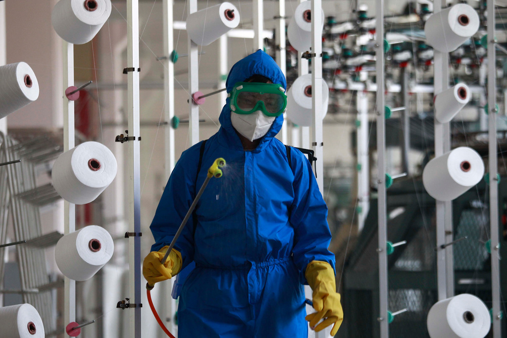 En anställd på en fabrik i Songyo-distriktet desinficerar arbetsgolvet i huvudstaden Pyongyang.