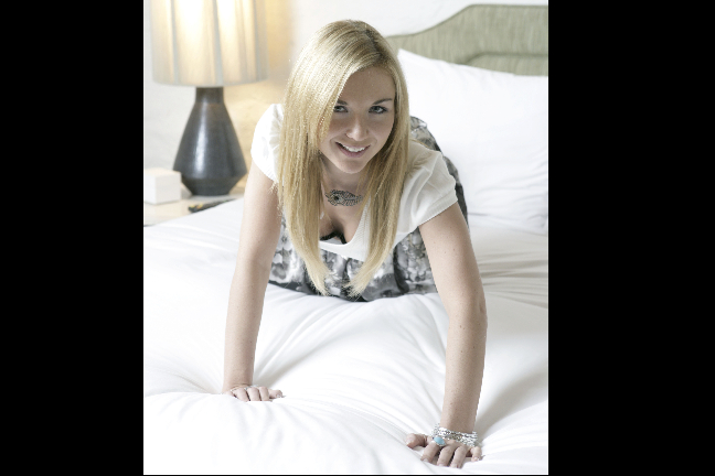 Violet Kowal poserar i en säng.