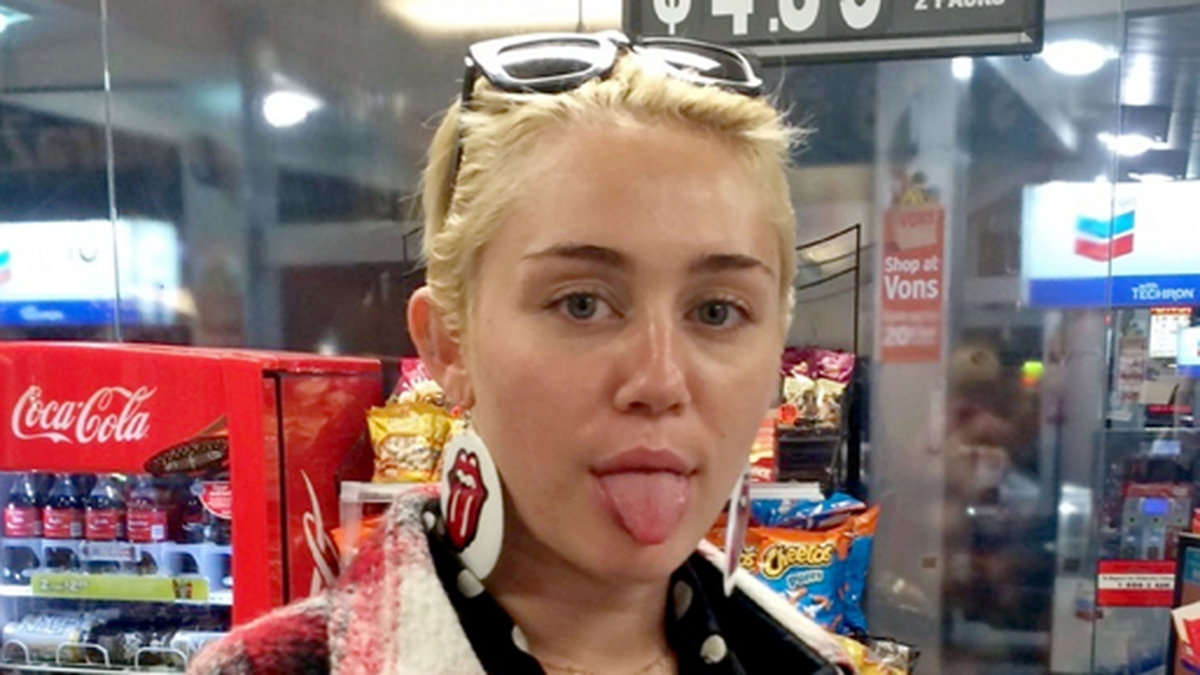 En osminkad Miley köper lite nödvändigheter på macken. 