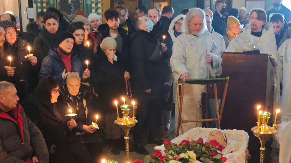 Aleksej Navalnyj i kistan under fredagens begravning. Vid hans sida sitter hans föräldrar.