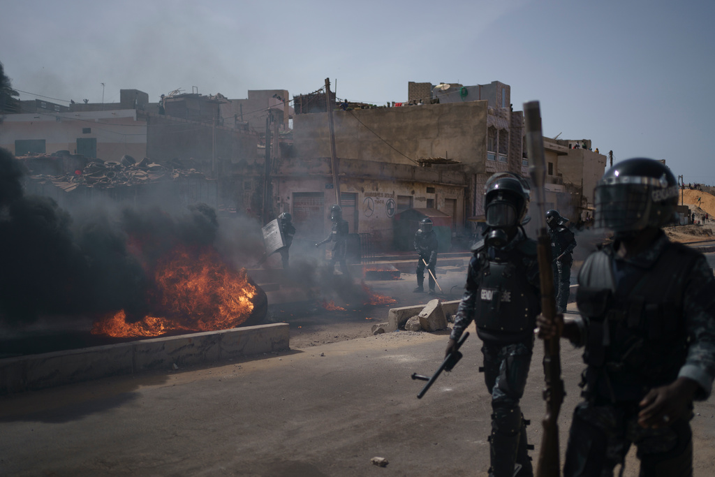 Polis avlägsnar brinnande däck i huvudstaden Dakar på fredagen efter en protest i området.