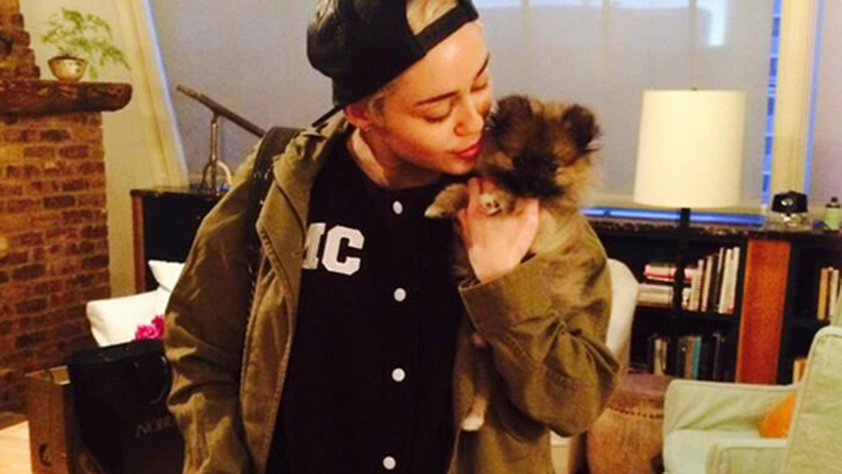 Miley Cyrus gosar med en hund. 