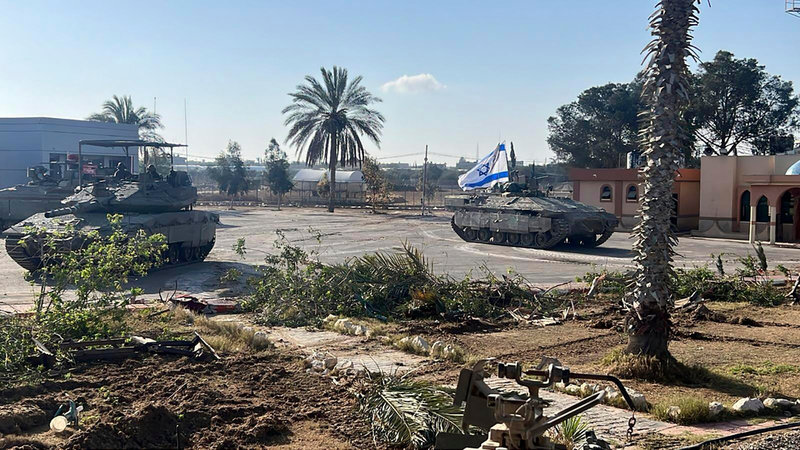 På denna bild, som tillhandahållits av Israels militär syns en stridsvagn med en israelisk flagga som kör in till Gaza-sidan vid gränsövergången Rafah på tisdagen.