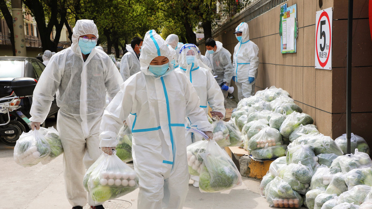 Volontärer bär livsmedelsleveranser till en nedstängd stadsdel i 25-miljonersstaden Shanghai i slutet av mars. Arkivbild