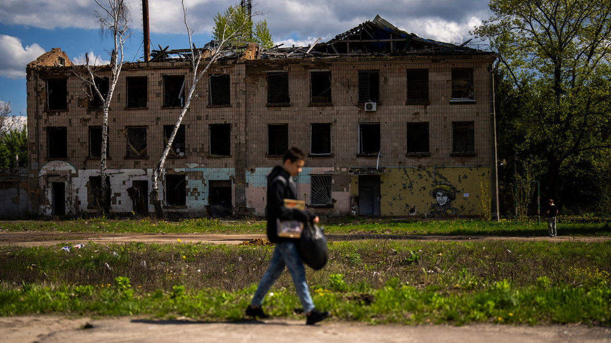 En ung man går förbi en delvis förstörd byggnad i Borodjanka norr om Ukrainas huvudstad Kiev. Bild från i lördags.