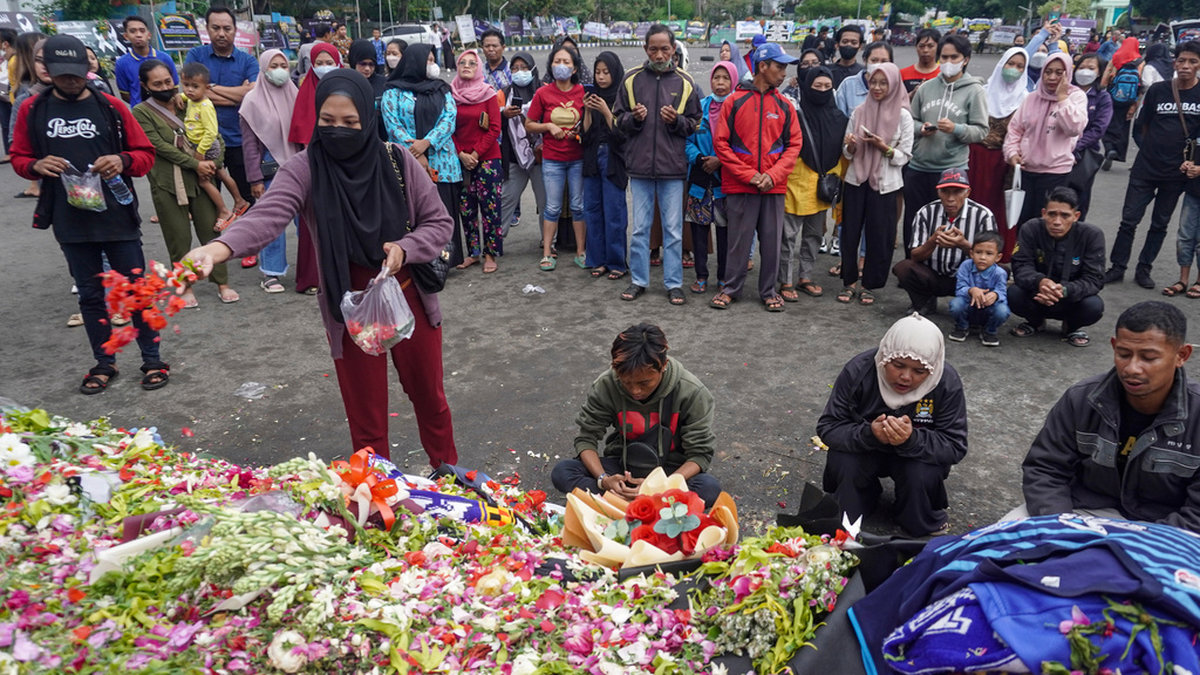 Folk lägger ner blommor utanför fotbollsstadion där tragedin inträffade.