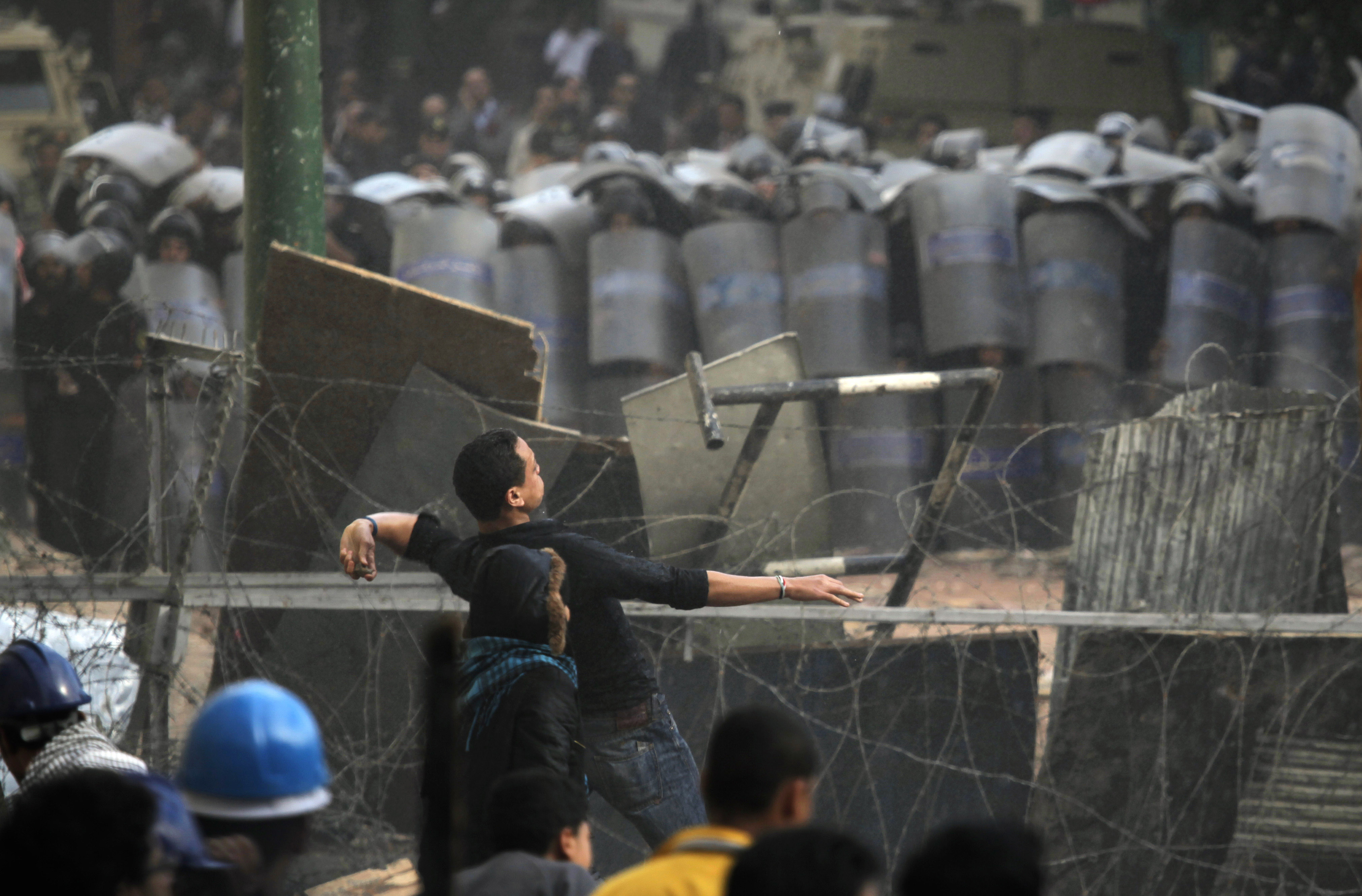 En demonstrant kastar sten mot militärpolisen.