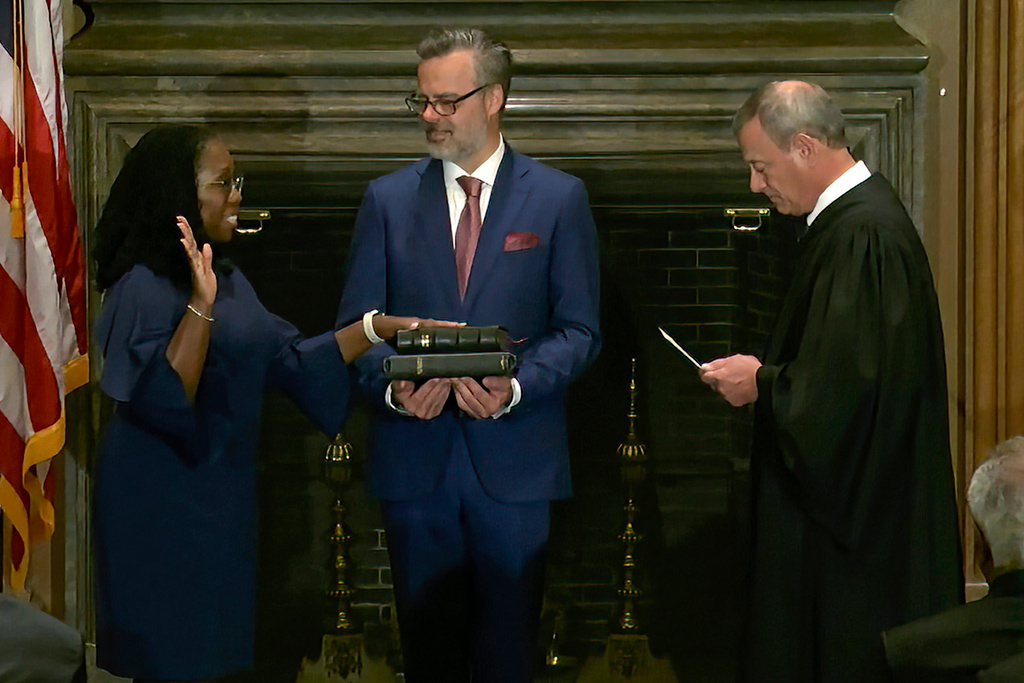 Ketanji Brown Jackson, till vänster, svärs som ny domare i Högsta domstolen i USA. I mitten håller hennes make Patrick Jackson bibeln och till höger HD:s chefsdomare John Roberts.