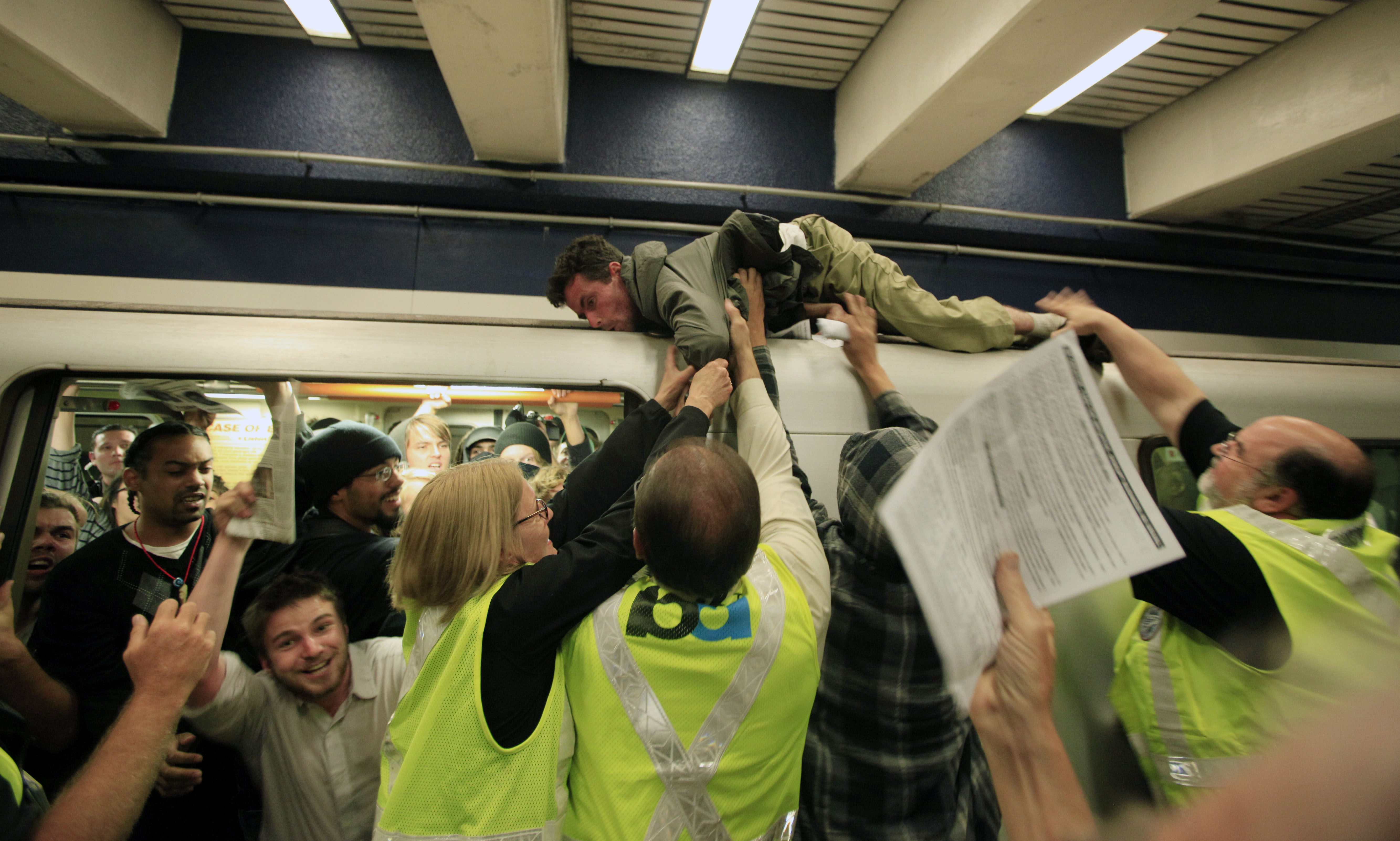 En man försöker klänga sig fast på tåget under tidigare protester mot BART.
