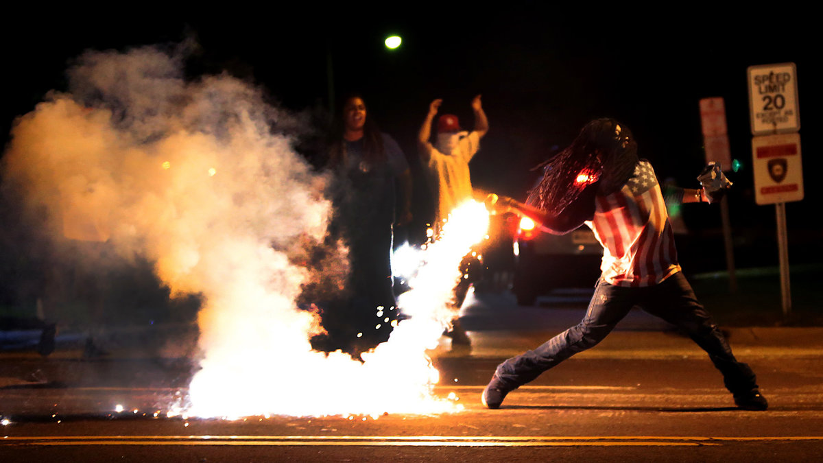 En demonstrant kastar molotovcocktail.
