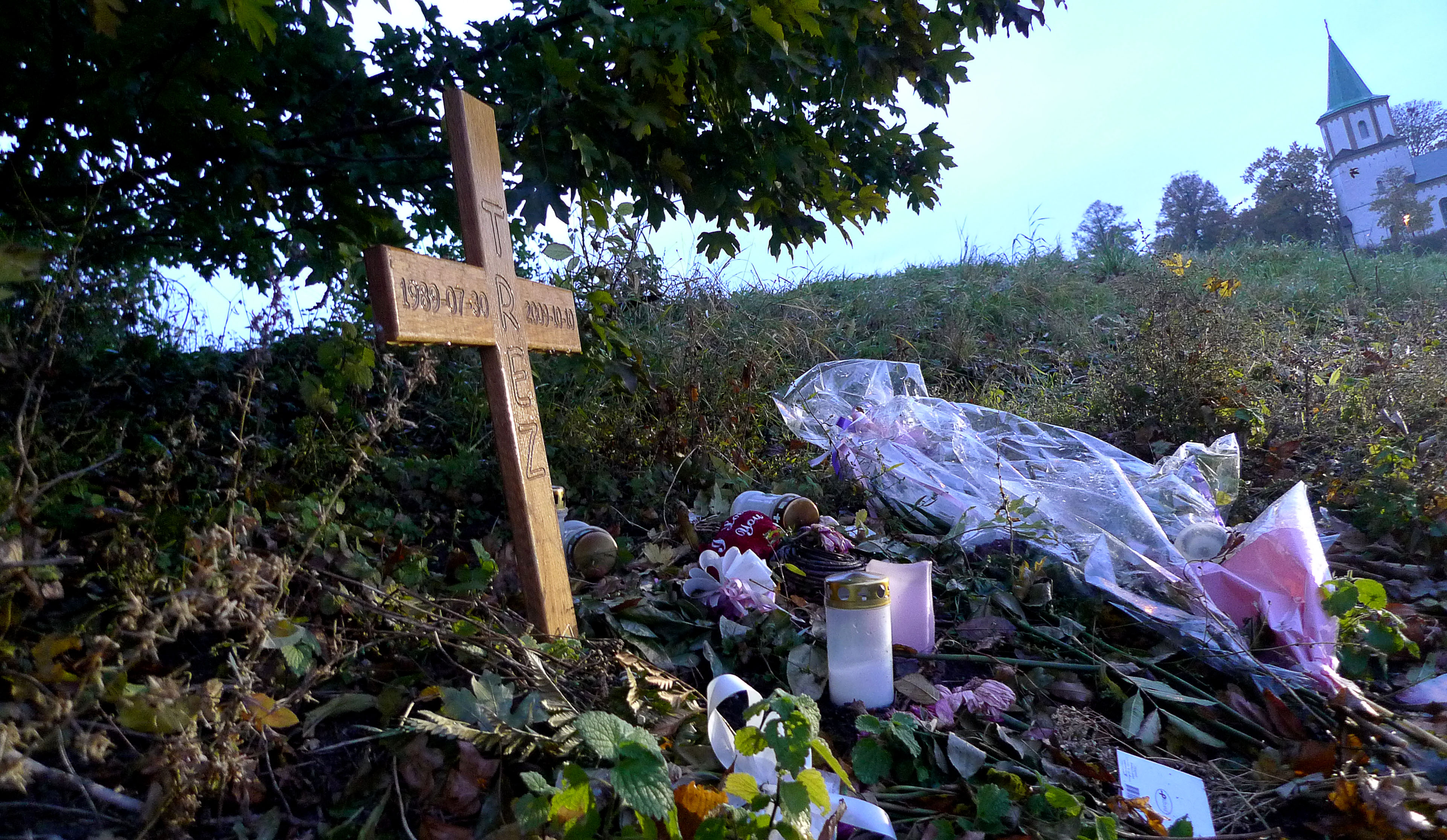 Ett kors står på den plats vid Ögårdsparken på Västra Skrävlingevägen i Malmö där Trez Persson West sköts till döds i oktober 2009. Mordet sätts i samband med den nye lasermannen.