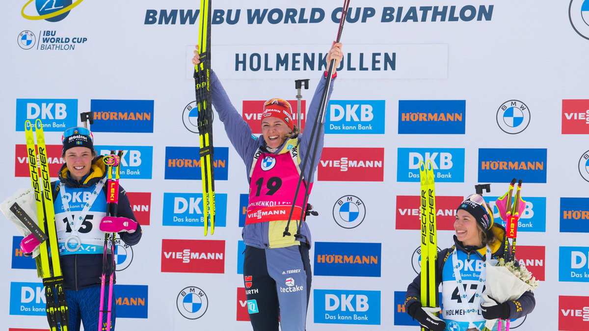 Hanna Öberg, (vänster) och Anna Magnusson, (höger), på pallen i Holmenkollen. Denise Herrmann-Wick (mitten) vann.