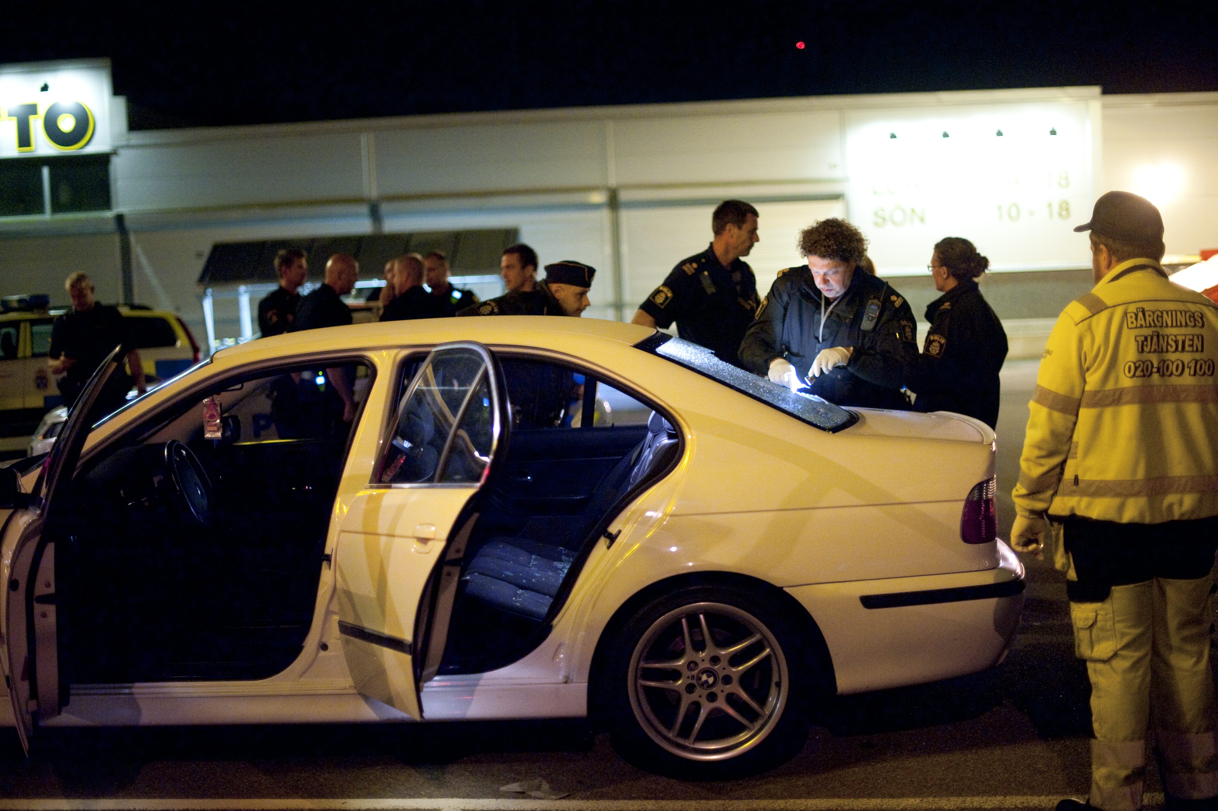 En vit BMW undersöks av polisen...