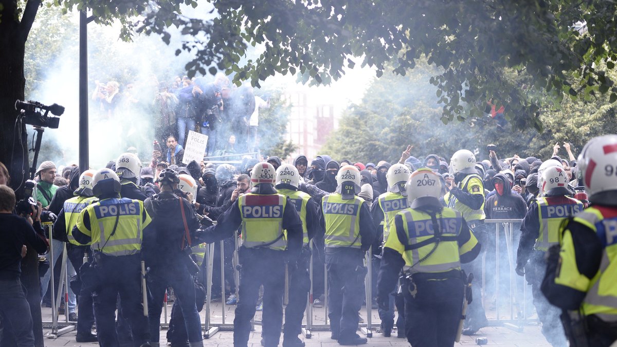 Polis framför kravallstaket i Kungsträdgården.