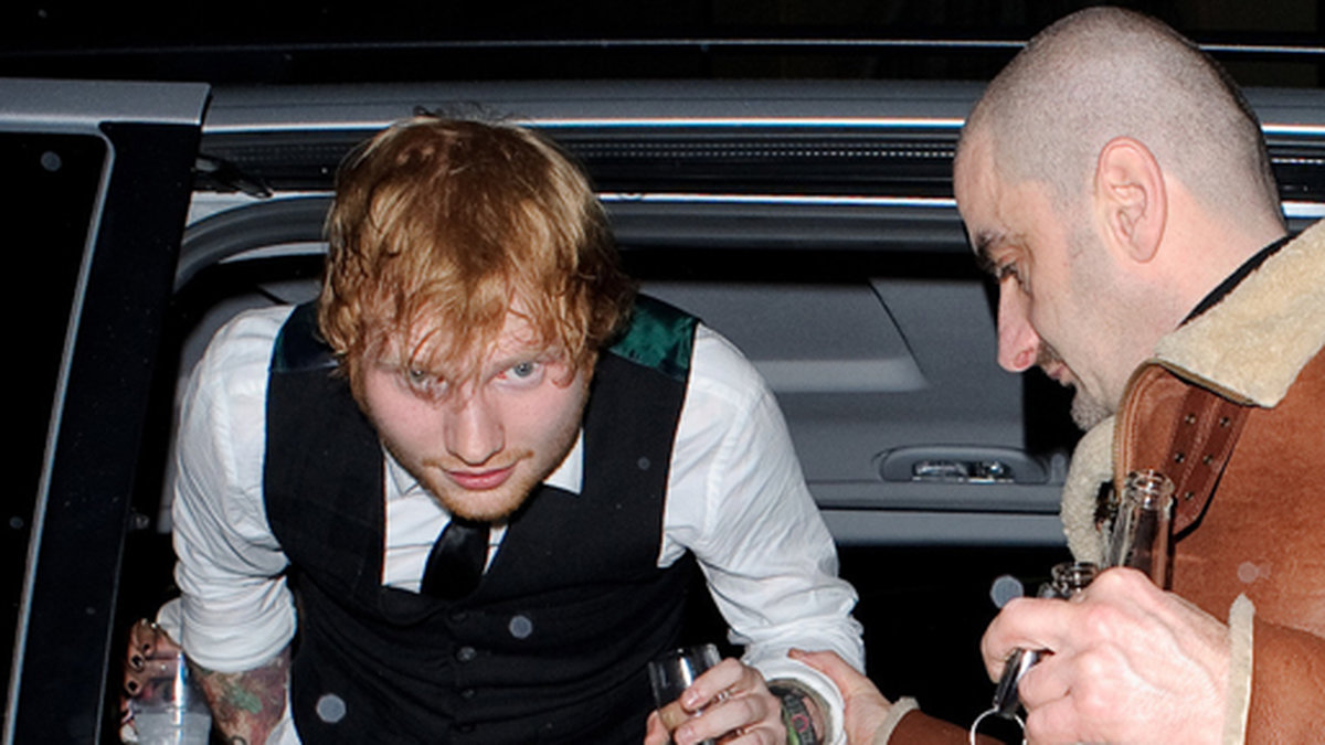 Det blev en livad kväll för Ed Sheeran. Här anländer han till Brit Awards efterfest med ett glas skumpa i högsta hugg. 