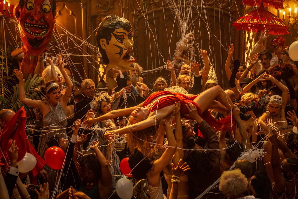Margot Robbie bärs runt under en av de storslagna festscenerna i 'Babylon'. Pressbild.
