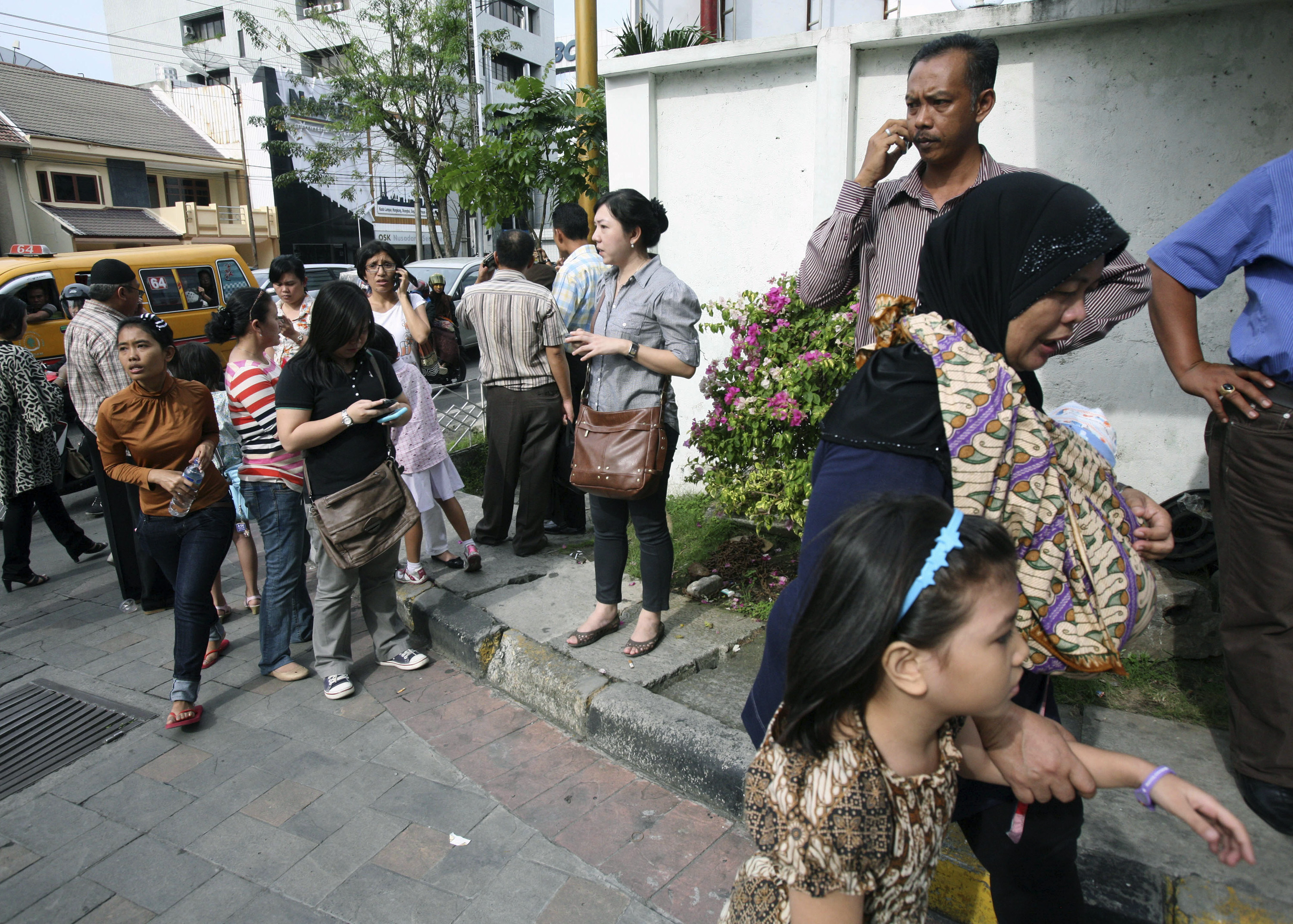 Människor står utanför ett shoppingcentrum i Medan, Indonesien, efter att ha blivit evakuerade.