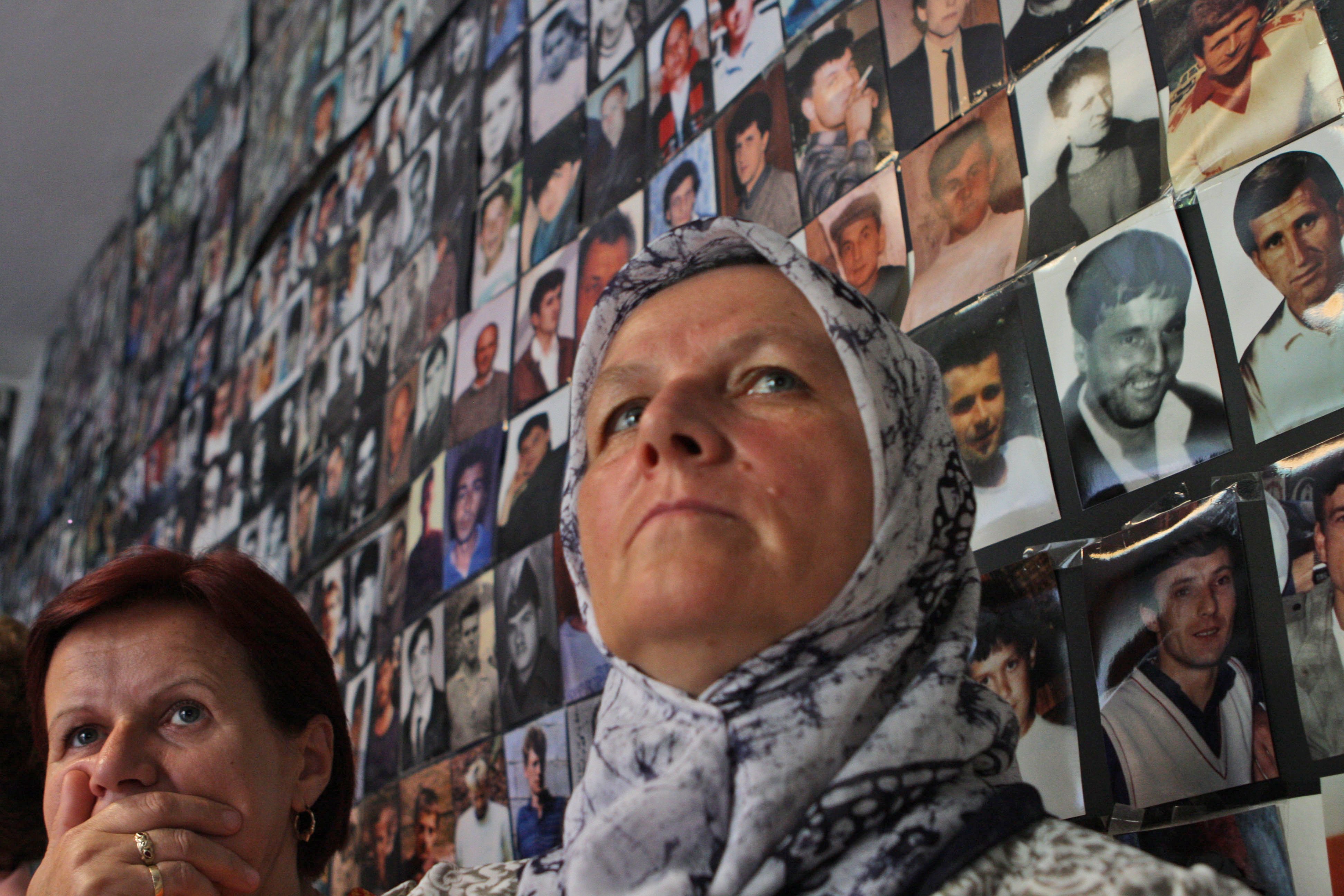 Kvinna framför bilder på offer från Srebrenica, där 8000 män och pojkar förlorade livet. 