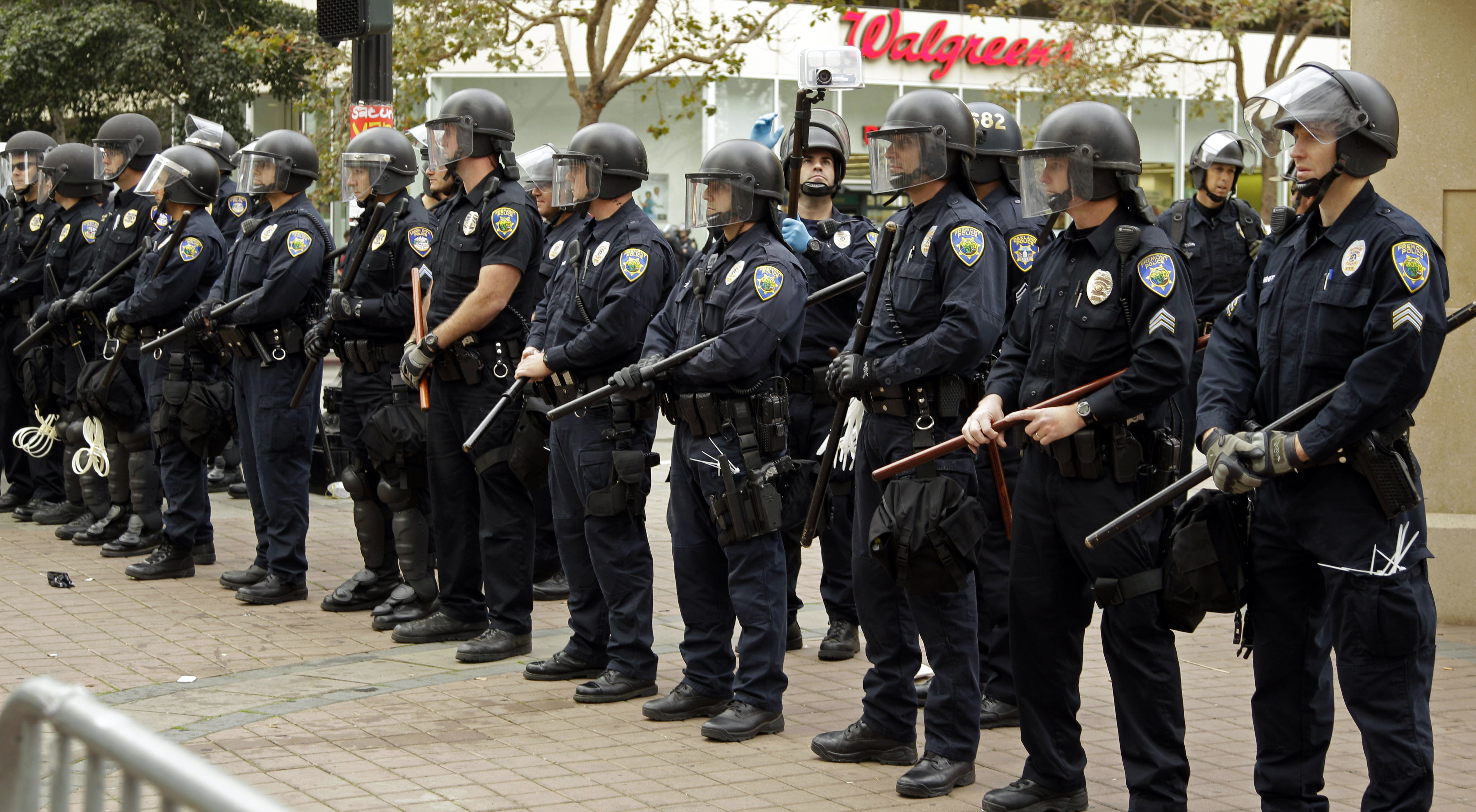 Kravallutrustad polis började riva ned det läger som Occupydemonstranterna byggt upp i Oakland.