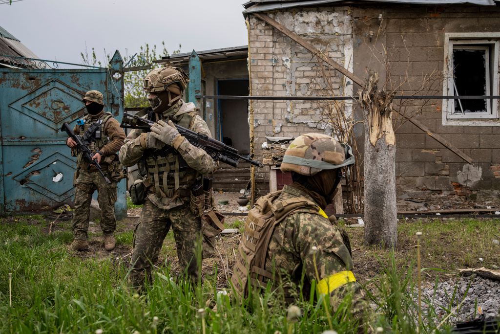 Ukrainska soldater undersöker en återtagen by i Charkivregionen i nordöstra Ukraina.