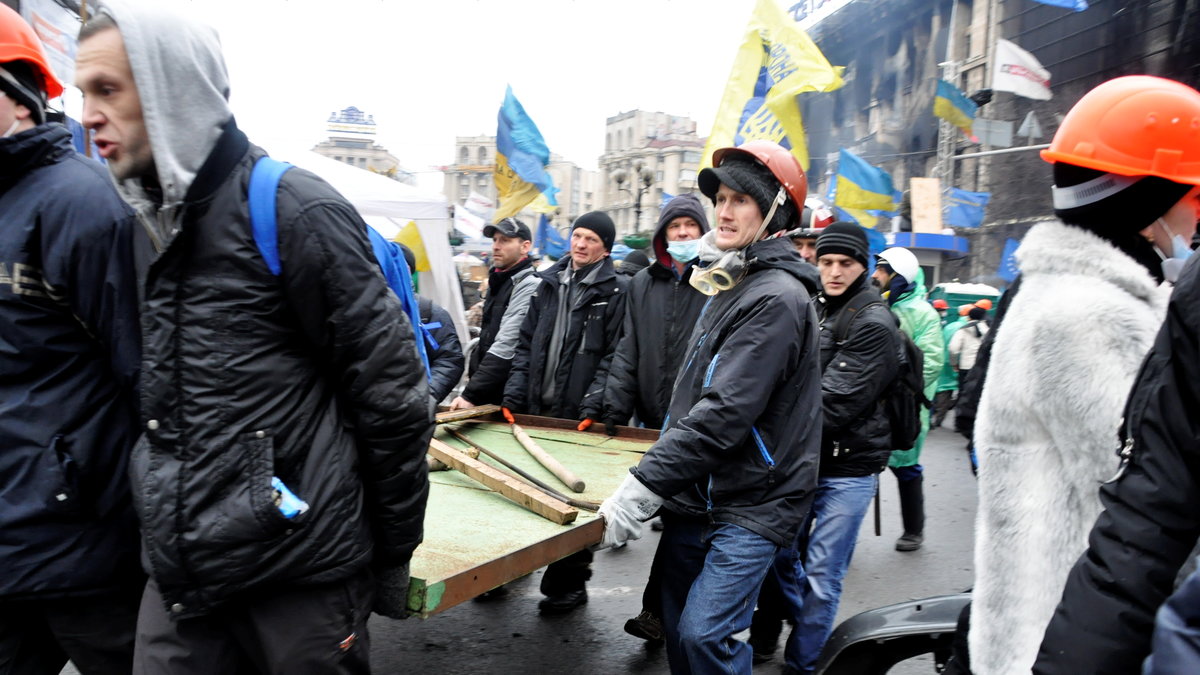 Demonstranter bär föremål för att förbättra barrikaderna, som förstärkts sedan onsdagens sammandrabbningar med polisen vid Självständighetstorget i Kiev.