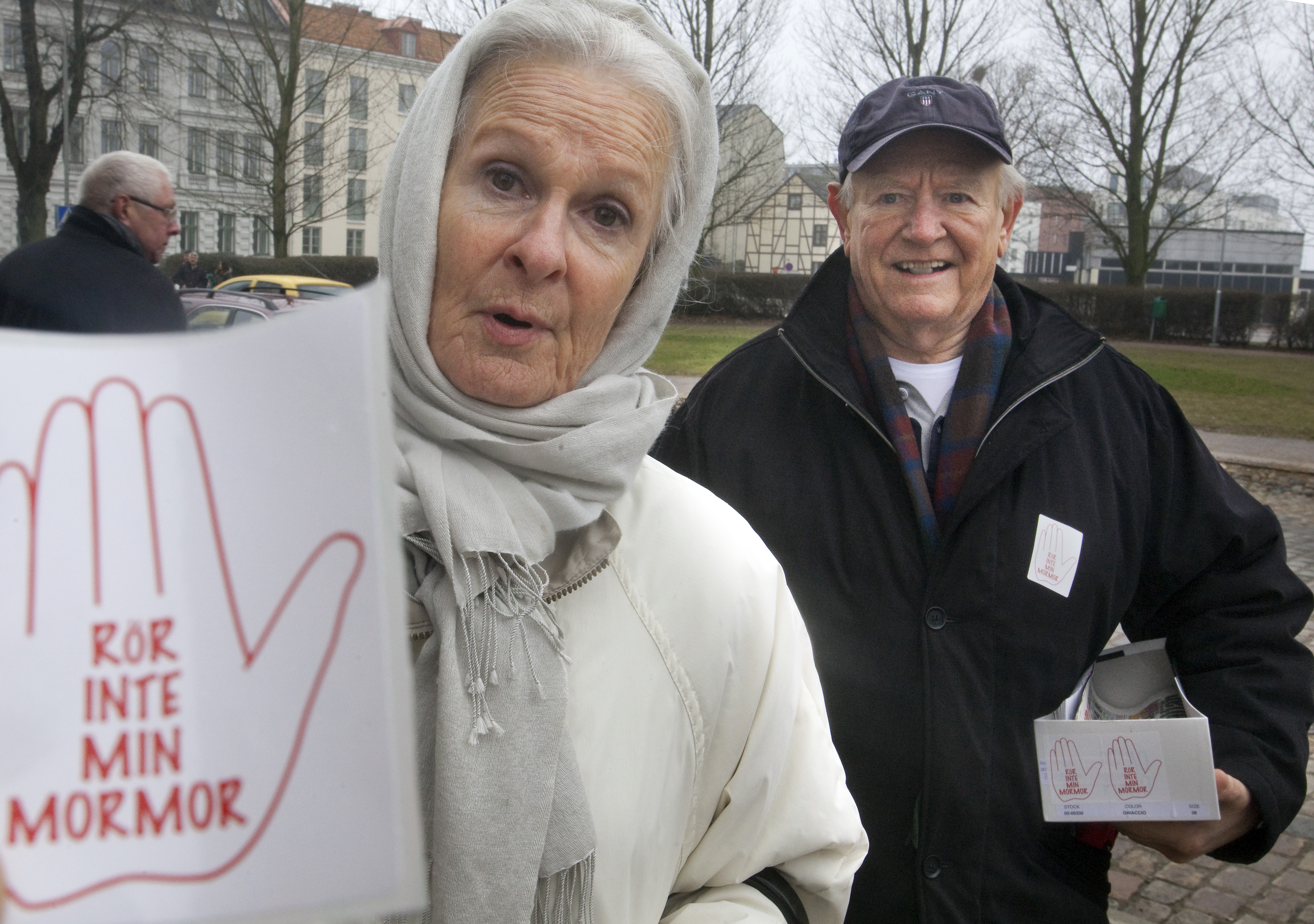 Ulrica Giebel och Franz Björklund delar ut klisterdekaler utanför kyrkan under en manifestation mot våld i Sofia Albertina kyrka i Landskrona.